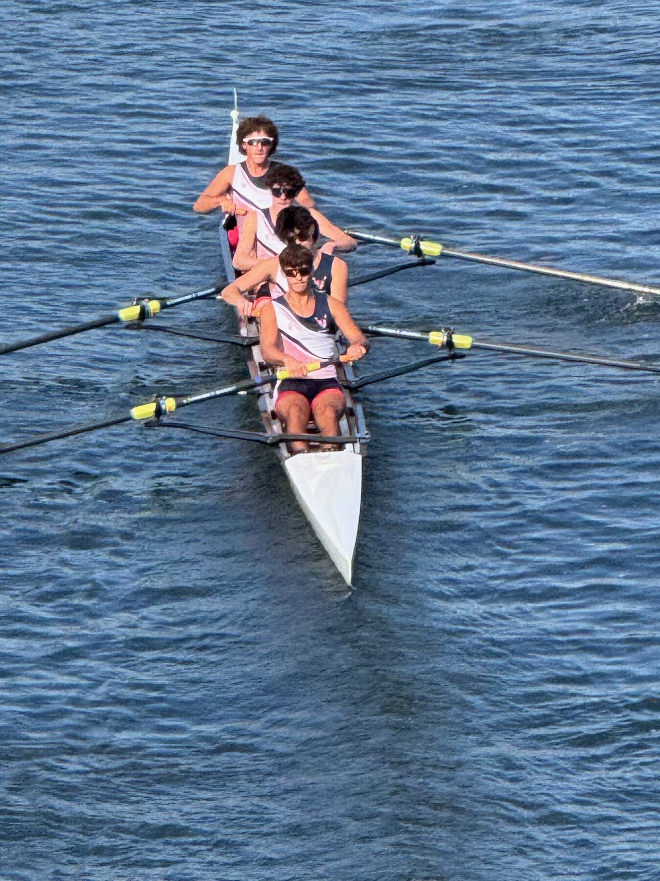 Aerial view of an LBRA four cutting across glassy water at sunset